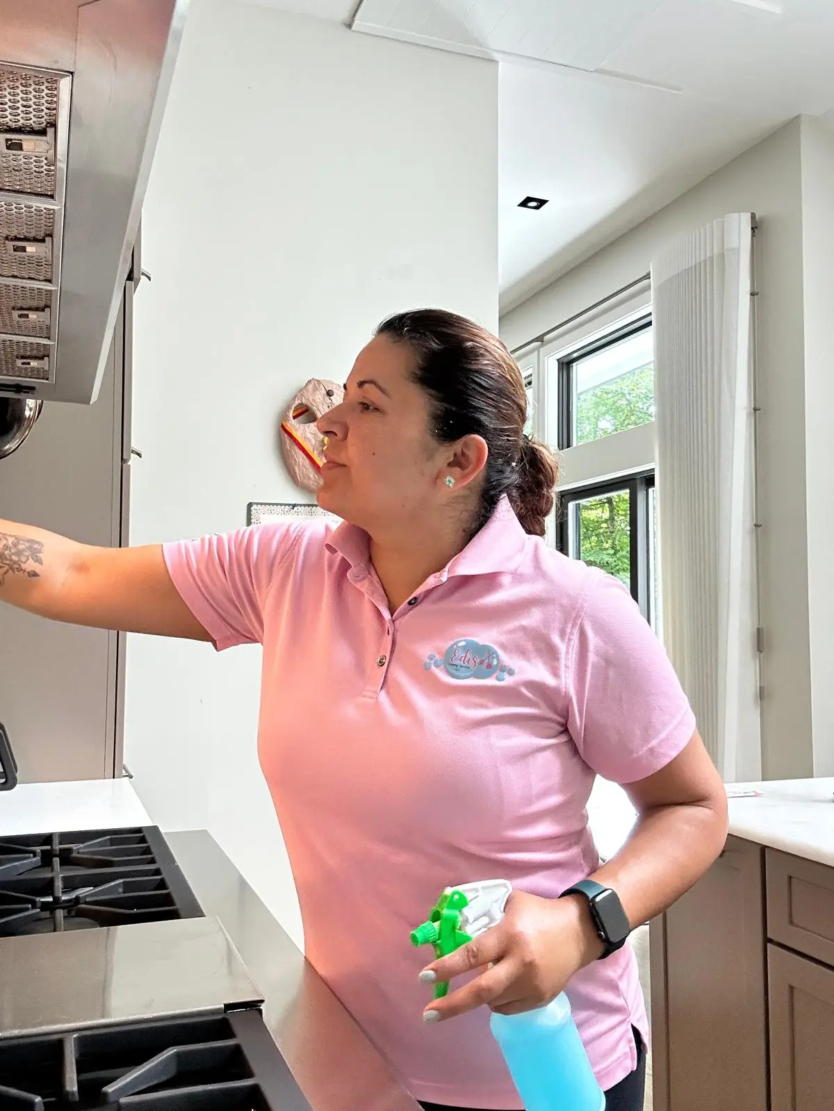Edis cleaner degreasing a kitchen range hood during a fall deep clean
