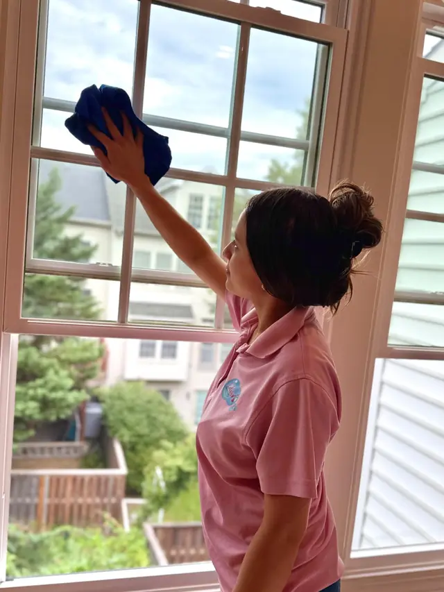 Cleaner wiping a window until streak-free